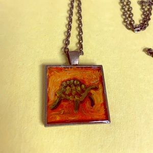 Glass and metal turtle necklace.